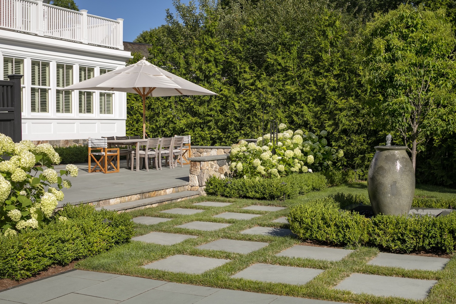 Landscape design with a house, patio, plantings, and hardscapes