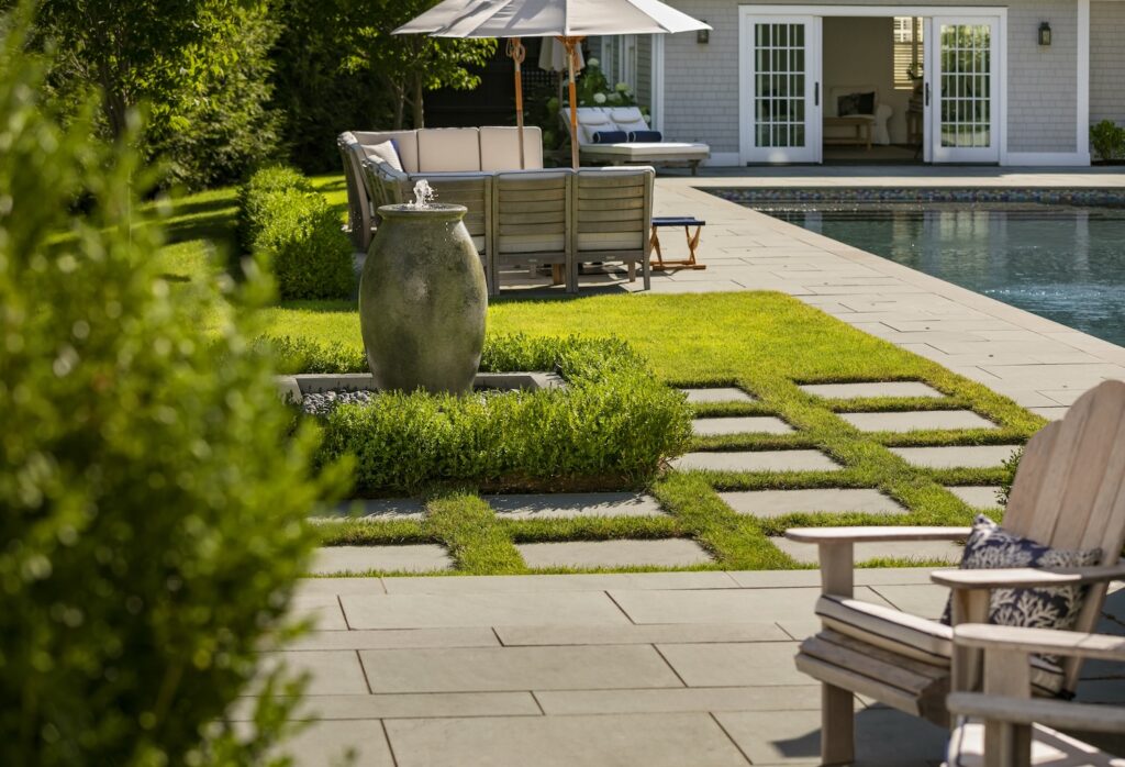 Landscape design with a house, patio, plantings, hardscapes, and pool